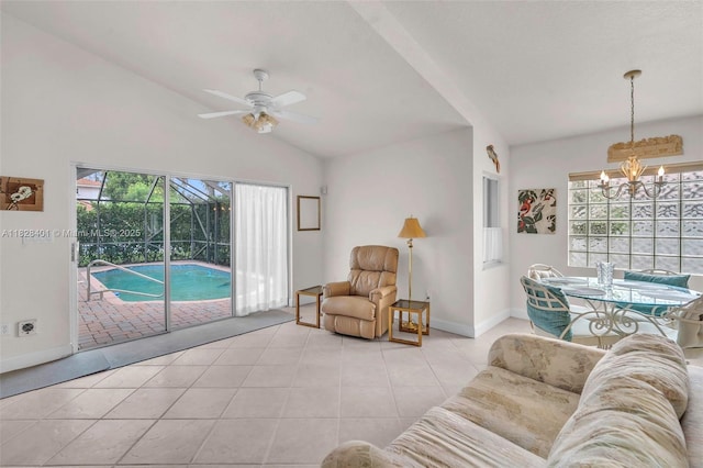 tiled living room with ceiling fan, a chandelier, and lofted ceiling