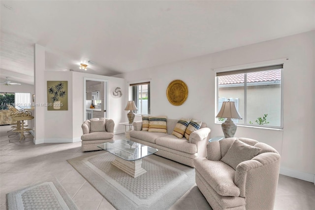 living area with light tile patterned floors and a ceiling fan