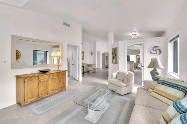 living room with light tile patterned floors, plenty of natural light, and arched walkways