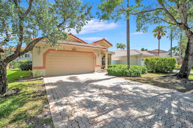 view of front of house with stucco siding, a garage, decorative driveway, and a tiled roof