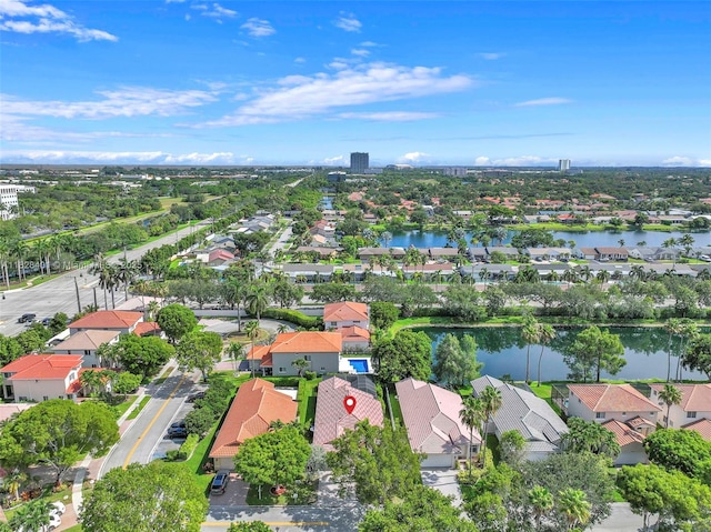 aerial view of property and surrounding area with nearby suburban area and a large body of water