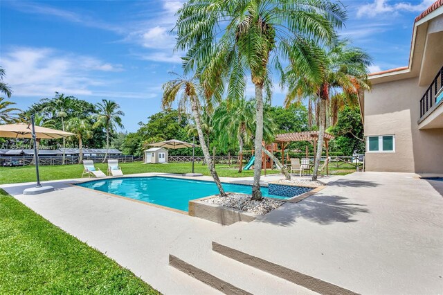 14100 SW 21st St, Davie, FL 33325 - outdoor pool featuring a patio, a storage unit, and a fenced backyard