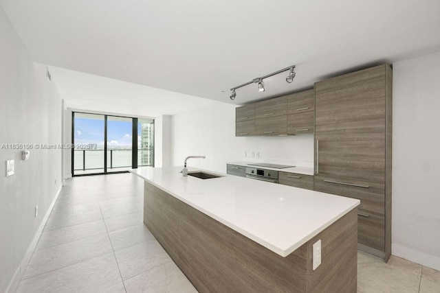 650 NE 32nd St Unit 2205, Miami, FL 33137 - kitchen with modern cabinets, light countertops, black electric stovetop, an island with sink, and light tile patterned flooring