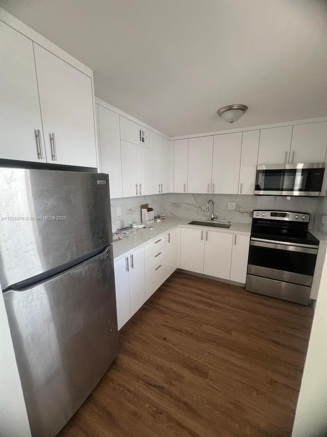 14180 SW 84th St Unit 407-G, Miami, FL 33183 - kitchen with stainless steel appliances, light countertops, decorative backsplash, and dark wood-type flooring