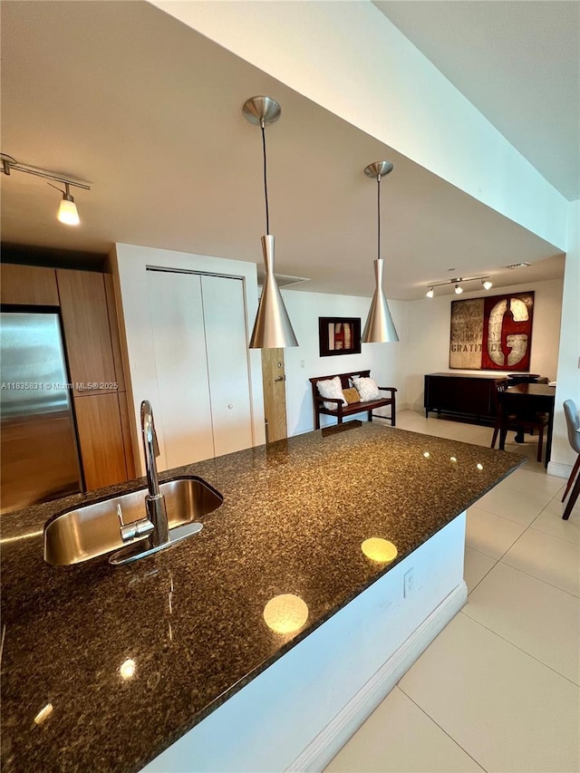 350 S Miami Ave Unit 2303, Miami, FL 33130 - kitchen with rail lighting, light tile patterned flooring, stainless steel refrigerator, decorative light fixtures, and dark stone counters