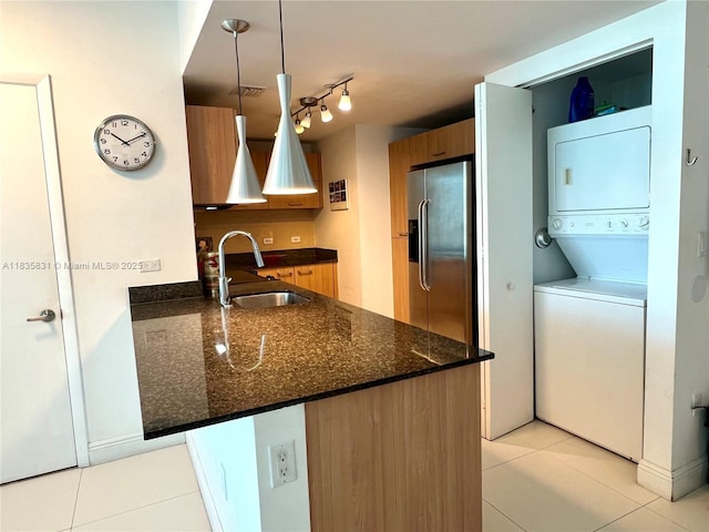 350 S Miami Ave Unit 2303, Miami, FL 33130 - kitchen with stacked washer / drying machine, stainless steel fridge, light tile patterned flooring, a peninsula, and dark stone countertops