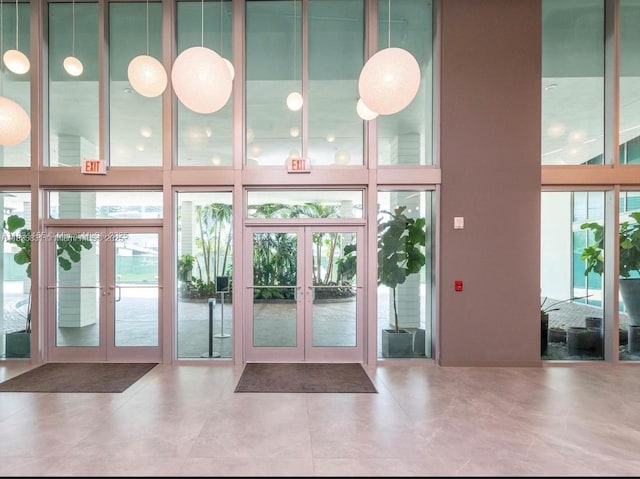 350 S Miami Ave Unit 2303, Miami, FL 33130 - doorway to outside featuring french doors, a towering ceiling, a water view, tile patterned floors, and a wall of windows