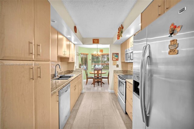 801 SW 138th Ave Unit 103E, Pembroke Pines, FL 33027 - kitchen with stainless steel appliances, a chandelier, light tile patterned flooring, light brown cabinets, and a textured ceiling