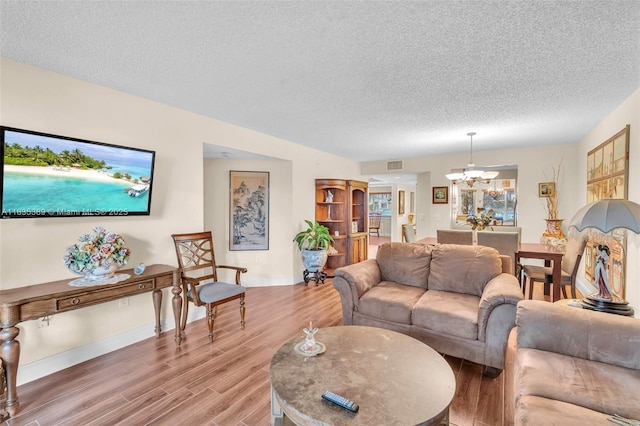 801 SW 138th Ave Unit 103E, Pembroke Pines, FL 33027 - living area featuring a chandelier, a textured ceiling, and light wood-style floors