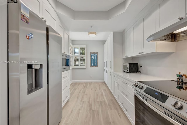 7588 SW 102nd St Unit 203, Pinecrest, FL 33156 - kitchen with appliances with stainless steel finishes, white cabinetry, light wood-style flooring, under cabinet range hood, and light countertops