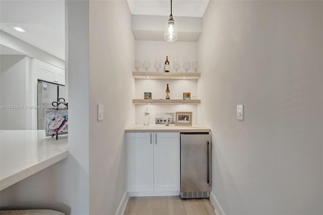 7588 SW 102nd St Unit 203, Pinecrest, FL 33156 - indoor wet bar featuring stainless steel fridge, light wood-type flooring, and pendant lighting