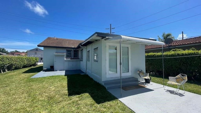 2993 SW 16th Ter, Miami, FL 33145 - back of property with stucco siding, a lawn, entry steps, and a patio