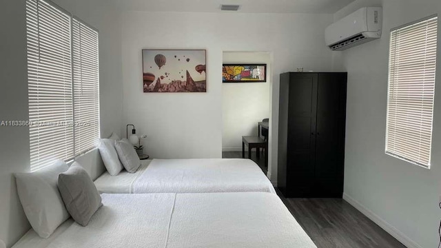 2993 SW 16th Ter, Miami, FL 33145 - bedroom featuring a wall mounted AC and dark wood-style floors