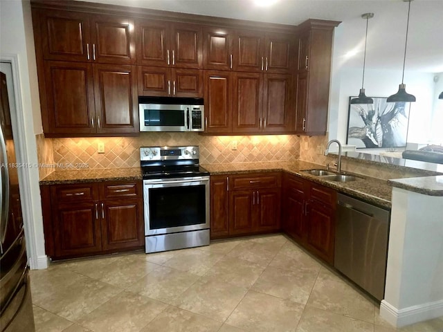 547 Cascade Falls Dr, Weston, FL 33327 - kitchen featuring stainless steel appliances, dark stone counters, decorative backsplash, a peninsula, and pendant lighting