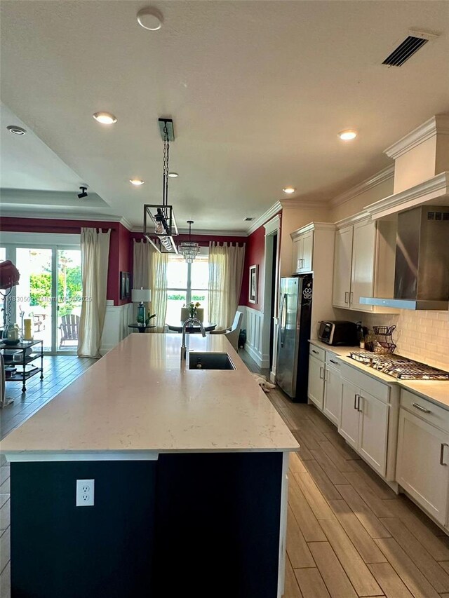 799 Hookline Cir, Loxahatchee, FL 33470 - kitchen featuring stainless steel appliances, crown molding, plenty of natural light, light wood-style floors, and white cabinetry