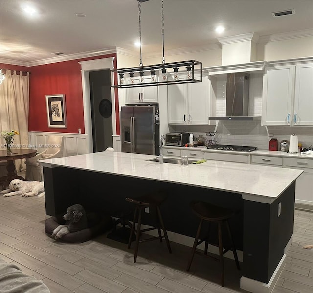 799 Hookline Cir, Loxahatchee, FL 33470 - kitchen with fridge with ice dispenser, wall chimney exhaust hood, a large island, ornamental molding, and white cabinetry