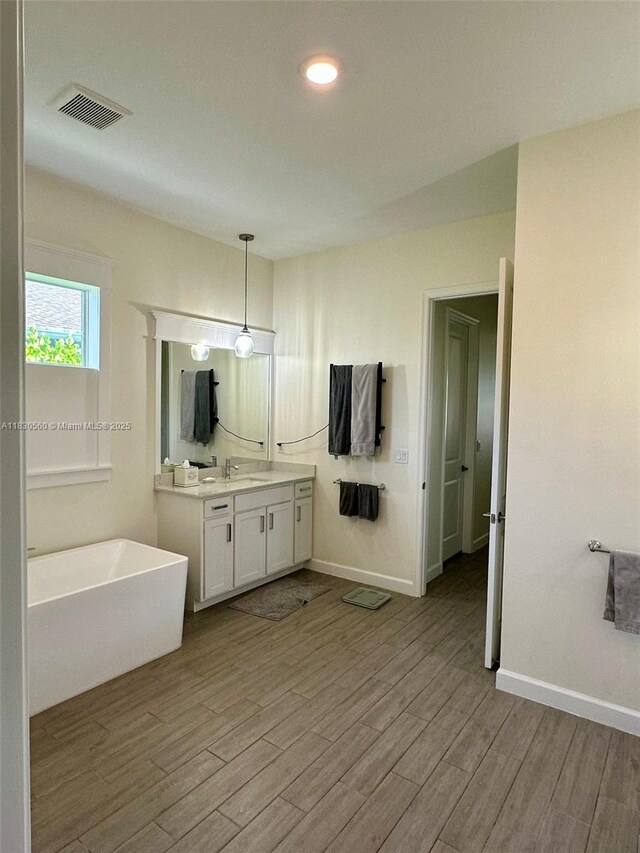 799 Hookline Cir, Loxahatchee, FL 33470 - bathroom with a freestanding tub, vanity, wood finished floors, and recessed lighting