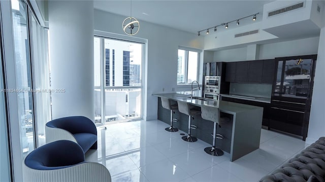 1080 Brickell Ave Unit 4209, Miami, FL 33131 - kitchen featuring modern cabinets, appliances with stainless steel finishes, light tile patterned floors, hanging light fixtures, and light countertops