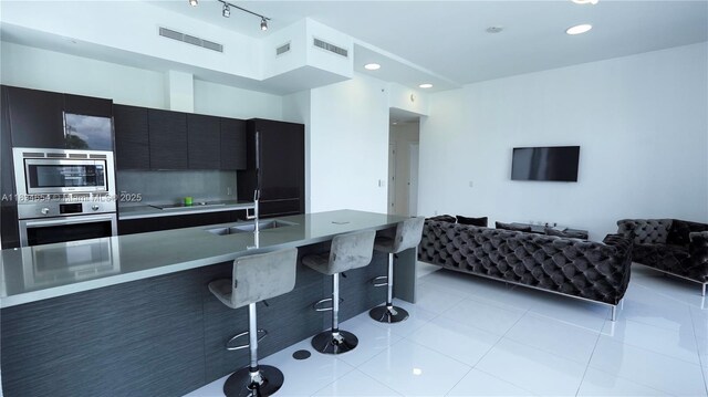 1080 Brickell Ave Unit 4209, Miami, FL 33131 - kitchen featuring stainless steel appliances, dark cabinets, a kitchen breakfast bar, modern cabinets, and open floor plan