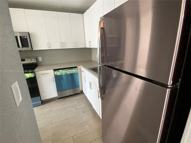 2025 NE 164th St Unit 807, North Miami Beach, FL 33162 - kitchen featuring stainless steel appliances, light countertops, white cabinets, and light tile patterned floors
