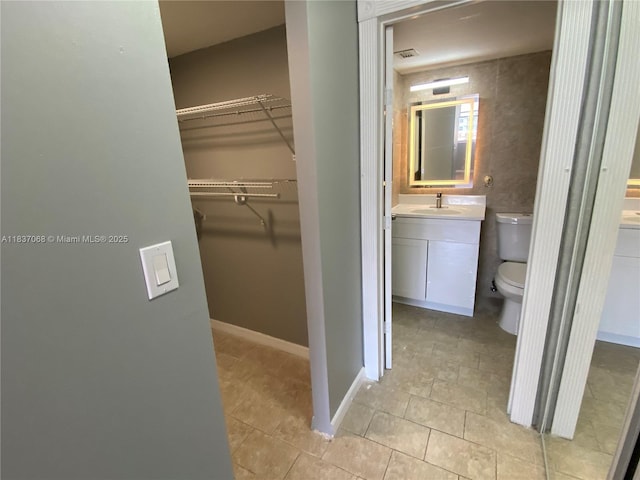 2025 NE 164th St Unit 807, North Miami Beach, FL 33162 - bathroom featuring vanity, tile patterned flooring, and a walk in closet