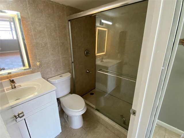 2025 NE 164th St Unit 807, North Miami Beach, FL 33162 - full bathroom featuring vanity, tile walls, a shower stall, and tile patterned floors
