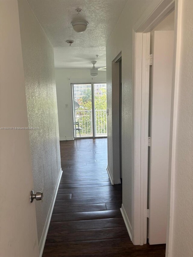2050 NE 167th St Unit 3-124, North Miami Beach, FL 33162 - hall featuring a textured wall, dark wood-style flooring, and a textured ceiling