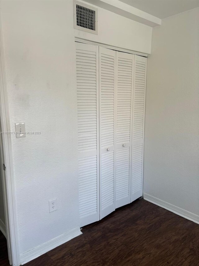 2050 NE 167th St Unit 3-124, North Miami Beach, FL 33162 - unfurnished bedroom featuring dark wood finished floors and a closet