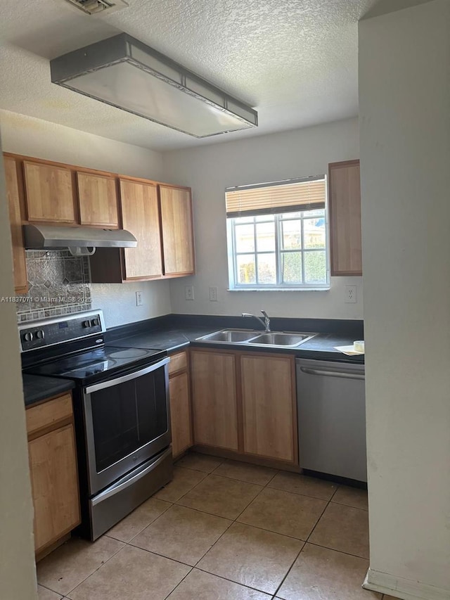 2050 NE 167th St Unit 3-124, North Miami Beach, FL 33162 - kitchen featuring appliances with stainless steel finishes, under cabinet range hood, dark countertops, a textured ceiling, and light tile patterned floors