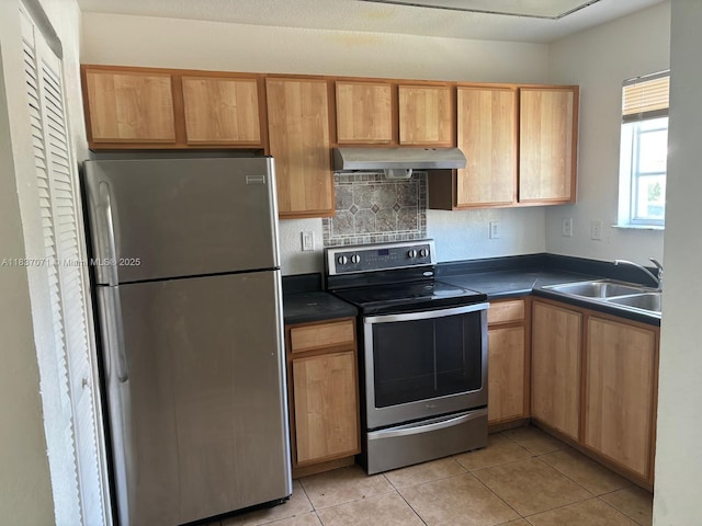 2050 NE 167th St Unit 3-124, North Miami Beach, FL 33162 - kitchen featuring appliances with stainless steel finishes, under cabinet range hood, dark countertops, and light tile patterned floors