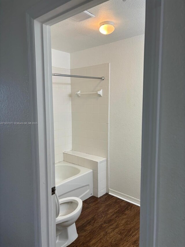 2050 NE 167th St Unit 3-124, North Miami Beach, FL 33162 - full bath with wood finished floors, a textured wall, and  shower combination