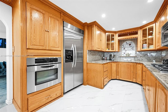 11055 NW 59th Ct, Hialeah, FL 33012 - kitchen featuring appliances with stainless steel finishes, light marble finish flooring, light stone countertops, glass insert cabinets, and recessed lighting