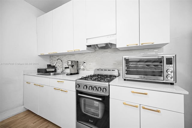 11055 NW 59th Ct, Hialeah, FL 33012 - kitchen featuring gas stove, light countertops, backsplash, custom range hood, and white cabinets