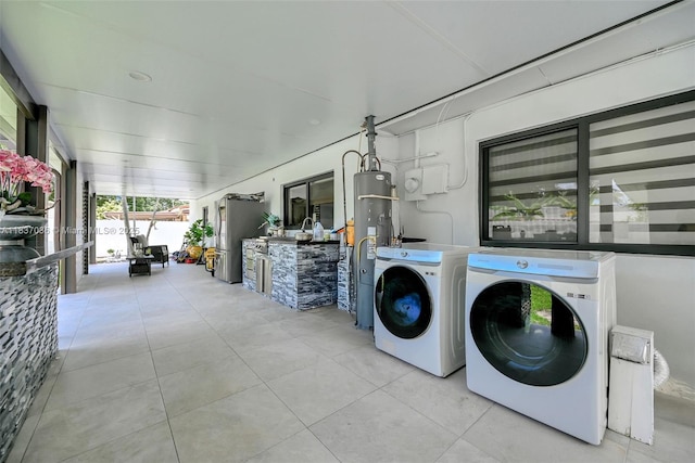 11055 NW 59th Ct, Hialeah, FL 33012 - laundry area featuring independent washer and dryer, tile patterned flooring, and water heater