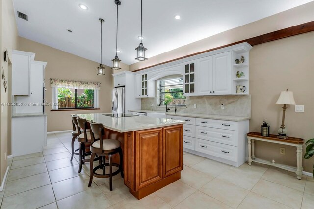 11321 NW 1st Ct, Coral Springs, FL 33071 - kitchen with stainless steel refrigerator with ice dispenser, a kitchen island, tasteful backsplash, glass insert cabinets, and lofted ceiling