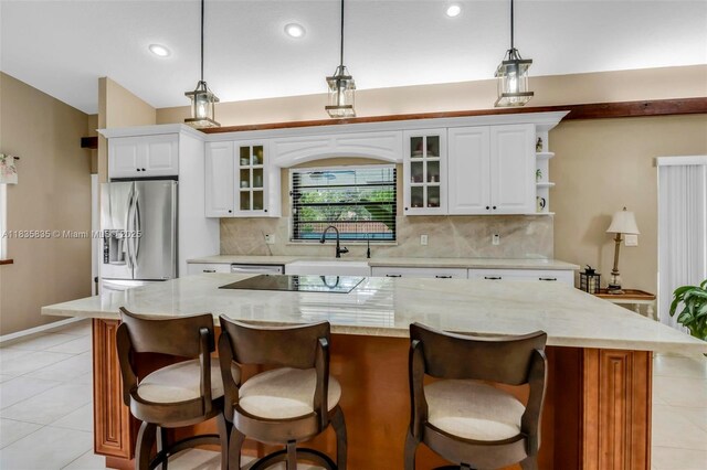 11321 NW 1st Ct, Coral Springs, FL 33071 - kitchen featuring appliances with stainless steel finishes, decorative backsplash, white cabinetry, a kitchen island, and pendant lighting