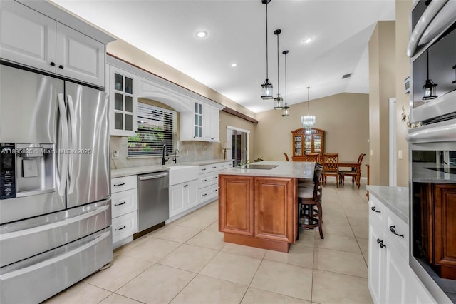 11321 NW 1st Ct, Coral Springs, FL 33071 - kitchen with appliances with stainless steel finishes, light countertops, vaulted ceiling, a kitchen breakfast bar, and glass insert cabinets