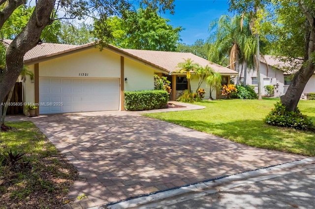 11321 NW 1st Ct, Coral Springs, FL 33071 - ranch-style house with a tiled roof, a garage, a front lawn, and decorative driveway