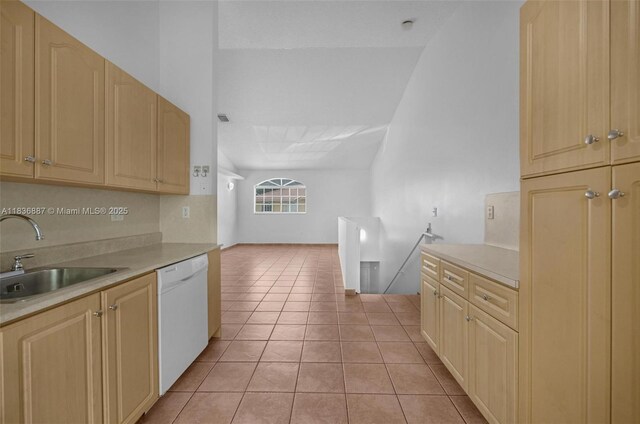 7506 W 20th Ave Unit 206, Hialeah, FL 33016 - kitchen with dishwasher, light countertops, light tile patterned floors, light brown cabinetry, and lofted ceiling