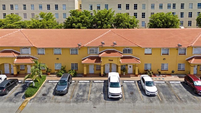 7506 W 20th Ave Unit 206, Hialeah, FL 33016 - view of front facade with a tile roof, uncovered parking, and stucco siding