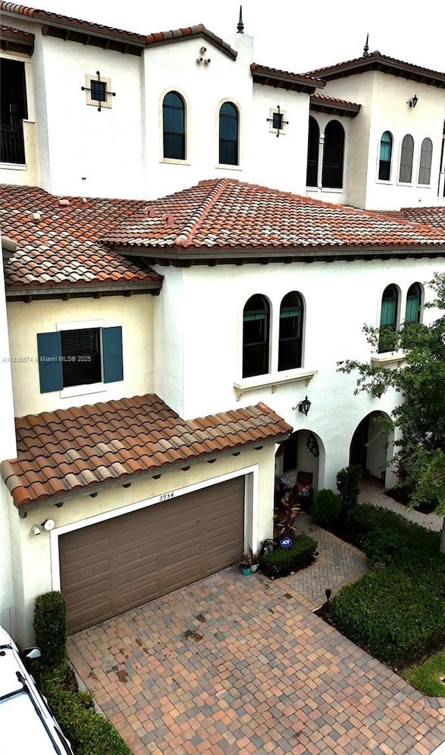2954 NW 124th Way, Sunrise, FL 33323 - mediterranean / spanish-style house featuring a garage, a tiled roof, stucco siding, and decorative driveway