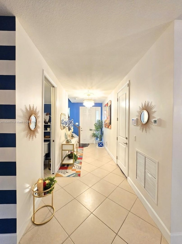 2954 NW 124th Way, Sunrise, FL 33323 - hallway with tile patterned floors, a chandelier, and a textured ceiling