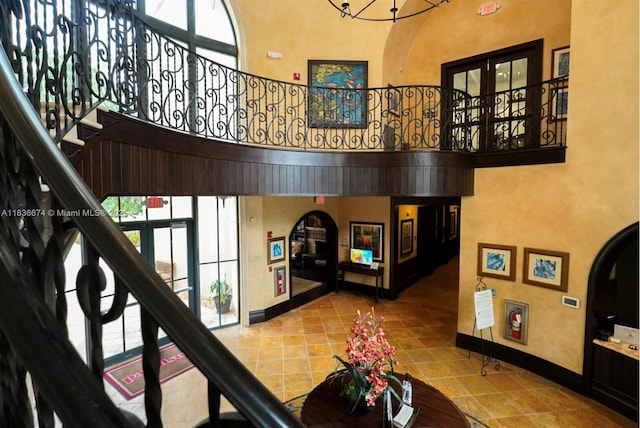 2954 NW 124th Way, Sunrise, FL 33323 - stairs with a high ceiling, arched walkways, tile patterned floors, and a chandelier