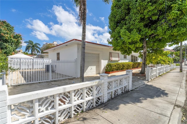 201 NW 14th Ave, Miami, FL 33125 - view of front of property with a fenced front yard, a garage, and stucco siding