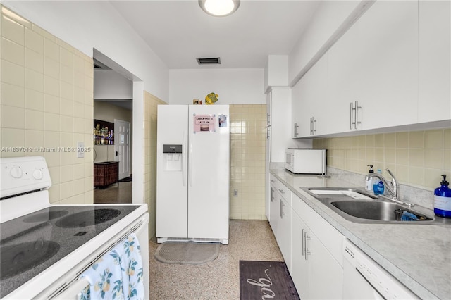 201 NW 14th Ave, Miami, FL 33125 - kitchen with white appliances, tile walls, dark speckled floor, white cabinetry, and light countertops