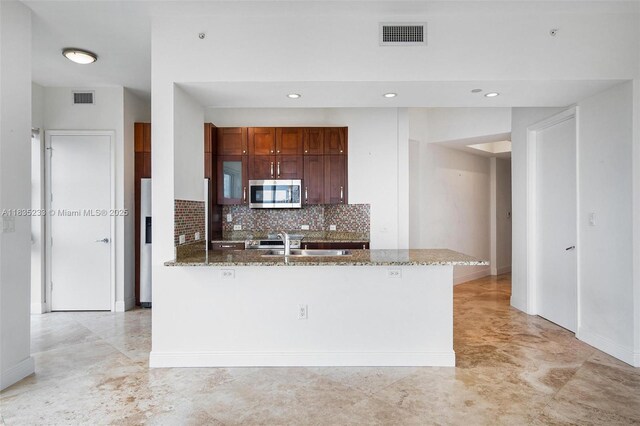 20000 E Country Club Dr Unit Ts02, Aventura, FL 33180 - kitchen with stainless steel appliances, a peninsula, light stone counters, tasteful backsplash, and recessed lighting