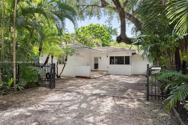 4050 Loquat Ave, Coconut Grove, FL 33133 - rear view of property with a tile roof, stucco siding, and a gate