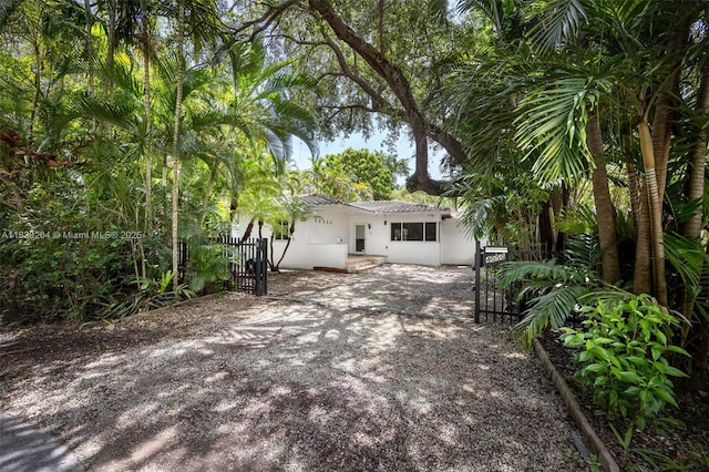 4050 Loquat Ave, Coconut Grove, FL 33133 - back of property with a gate, stucco siding, and driveway