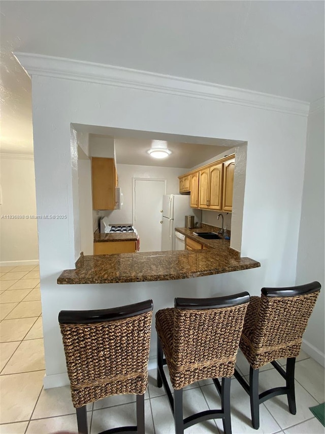6900 N Kendall Dr Unit A102, Pinecrest, FL 33156 - kitchen with freestanding refrigerator, crown molding, a kitchen bar, light tile patterned floors, and a peninsula