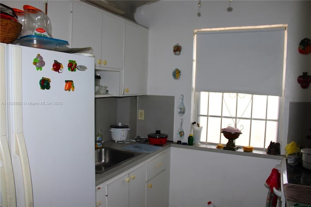 1154 W 35th St Unit 221, Hialeah, FL 33012 - kitchen with freestanding refrigerator and white cabinetry
